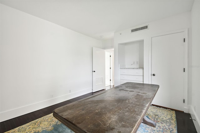 bedroom with visible vents, baseboards, and dark wood-style floors