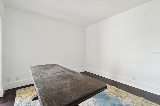 interior space featuring dark wood-style flooring and baseboards