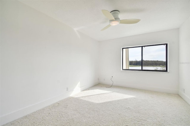 empty room featuring baseboards, a ceiling fan, and carpet