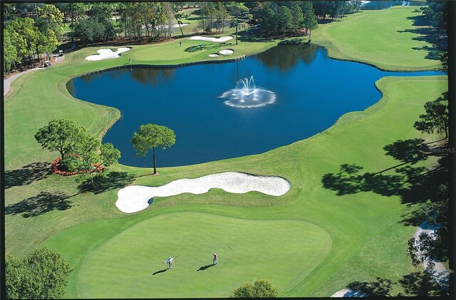 drone / aerial view featuring view of golf course and a water view
