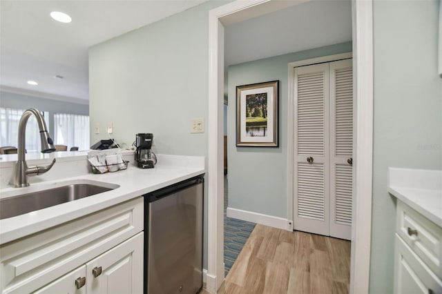 kitchen featuring white cabinetry, light hardwood / wood-style floors, sink, and dishwasher