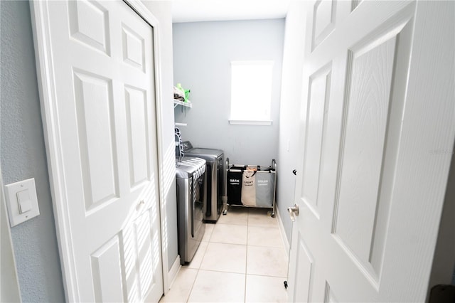 laundry area with washing machine and dryer and light tile patterned floors