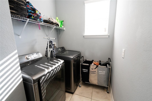 laundry room with washing machine and dryer and light tile patterned floors