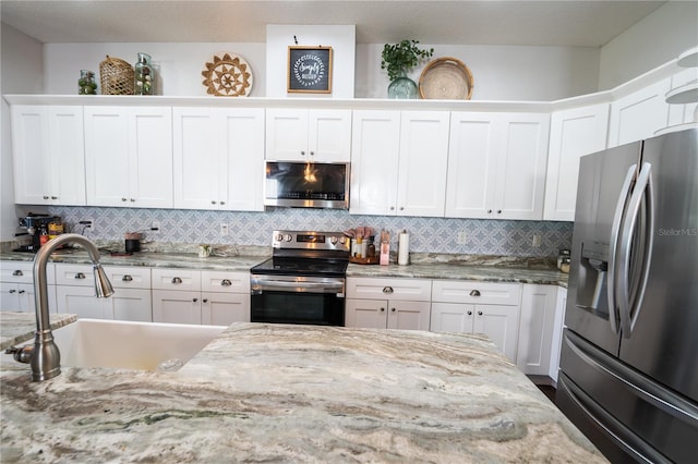 kitchen featuring appliances with stainless steel finishes, sink, and white cabinets