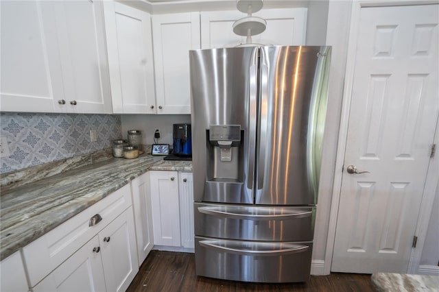 kitchen featuring stainless steel fridge, white cabinetry, light stone counters, and dark hardwood / wood-style flooring