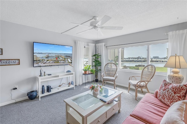 carpeted living room with ceiling fan and a textured ceiling