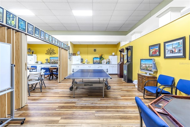 playroom featuring a drop ceiling and light hardwood / wood-style floors