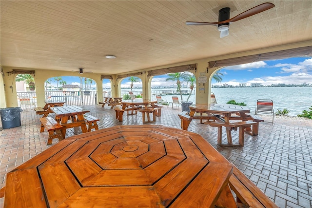 exterior space featuring wooden ceiling, ceiling fan, and a water view