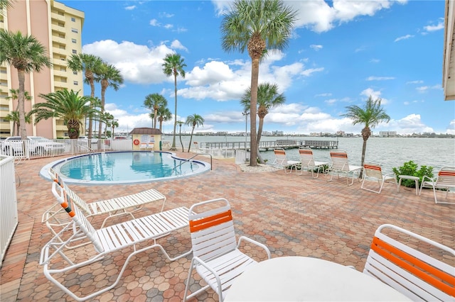 view of swimming pool featuring a patio area and a water view