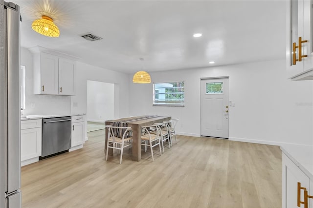 dining room with a barn door and light wood-type flooring