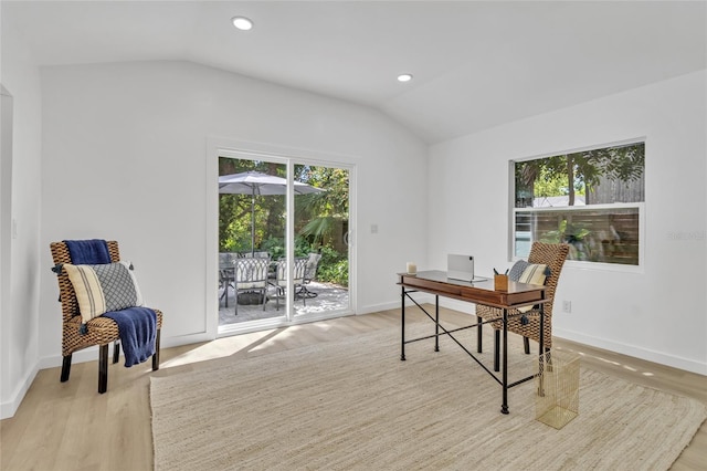 office area with light hardwood / wood-style floors and vaulted ceiling