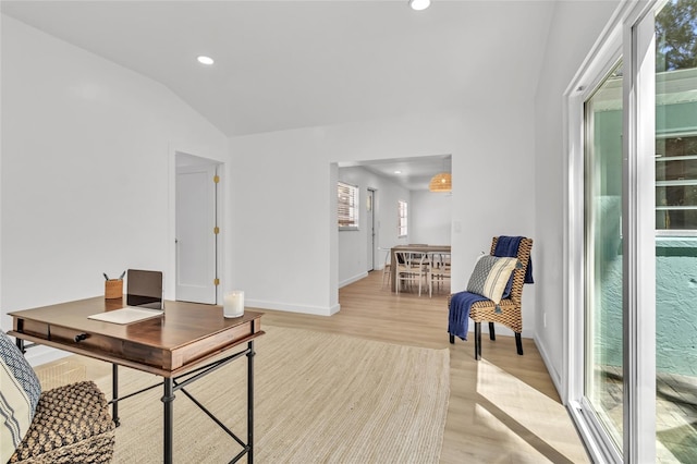 office featuring lofted ceiling and light hardwood / wood-style flooring