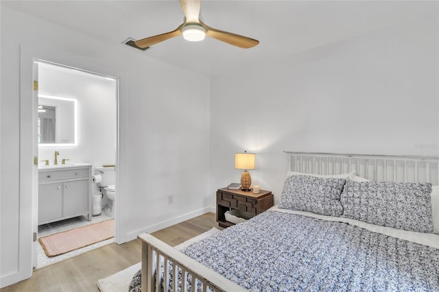 bedroom featuring connected bathroom, ceiling fan, light hardwood / wood-style flooring, and sink