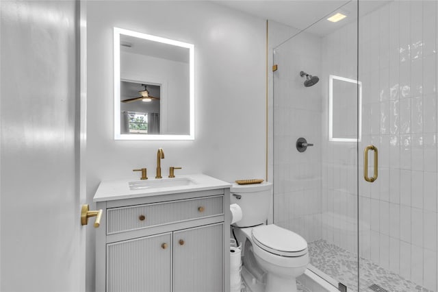 bathroom with toilet, walk in shower, vanity, and ceiling fan