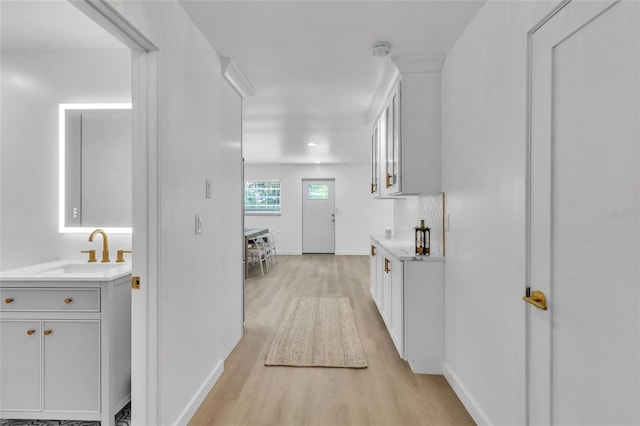 hallway featuring sink and light hardwood / wood-style flooring