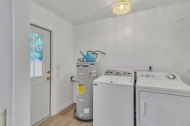 laundry area with light wood-type flooring, washer and clothes dryer, and water heater