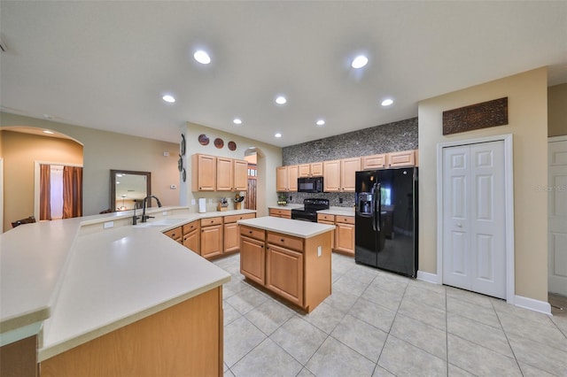 kitchen with sink, light tile patterned floors, a center island, black appliances, and kitchen peninsula