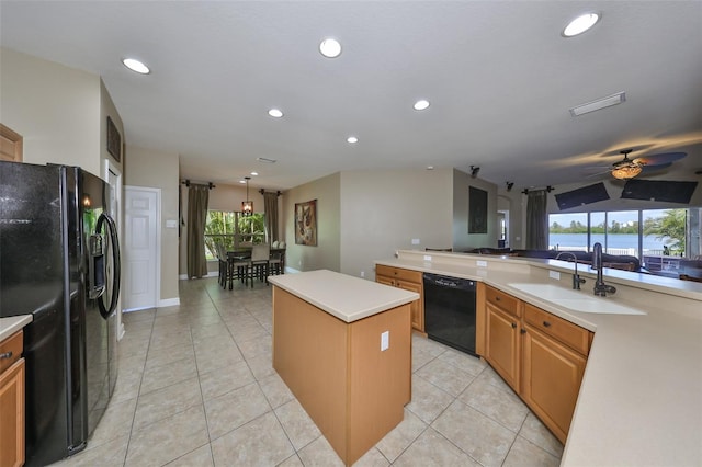 kitchen featuring sink, black appliances, a healthy amount of sunlight, and a kitchen island