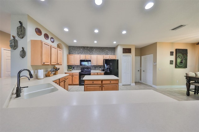 kitchen with light brown cabinetry, sink, black appliances, light tile patterned floors, and backsplash