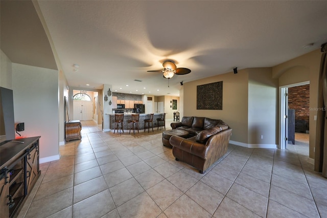 living room featuring light tile patterned flooring and ceiling fan