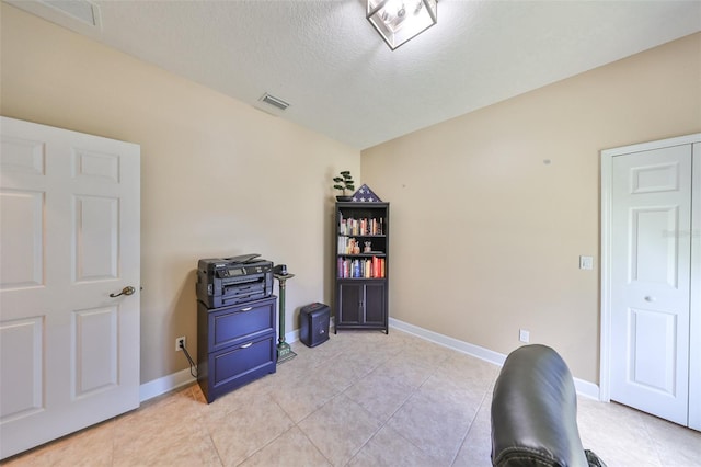 misc room with light tile patterned flooring and a textured ceiling