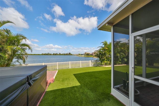 view of yard with a water view and a hot tub