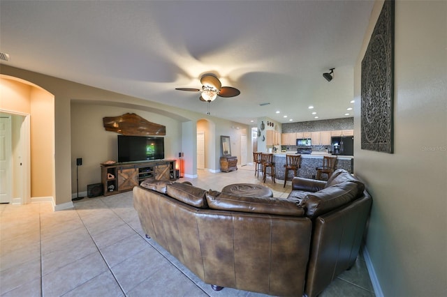 living room with ceiling fan and light tile patterned flooring