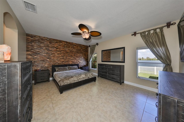 bedroom with ceiling fan and a textured ceiling