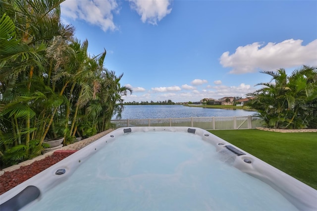 view of yard with a hot tub and a water view