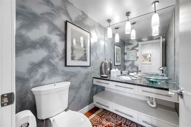 bathroom with toilet, baseboards, wood finished floors, and vanity
