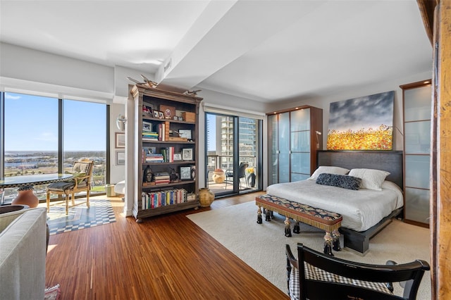 bedroom with access to outside and wood finished floors