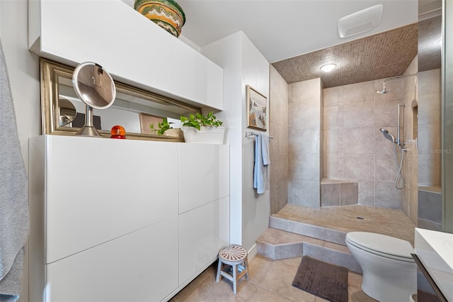 bathroom featuring vanity, tiled shower, toilet, and tile patterned floors