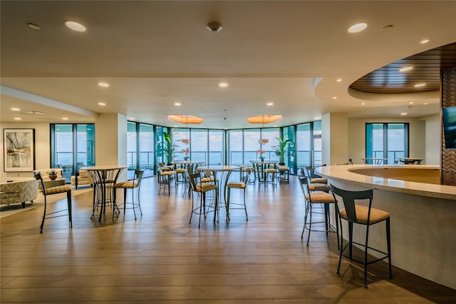 dining room featuring wood-type flooring and floor to ceiling windows