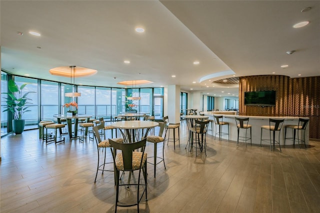 dining space featuring expansive windows, recessed lighting, and wood finished floors