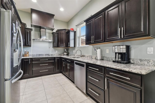 kitchen with light stone counters, light tile patterned floors, sink, wall chimney exhaust hood, and stainless steel appliances