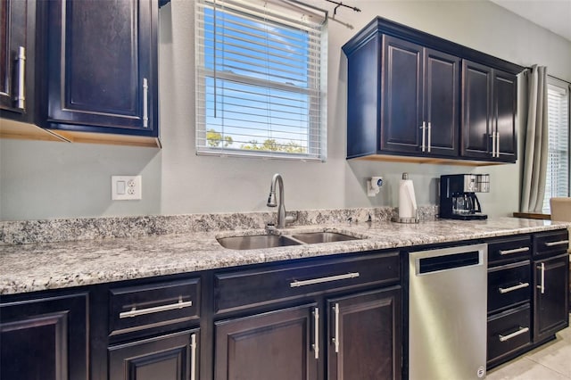 kitchen featuring light stone counters, light tile patterned flooring, sink, and stainless steel dishwasher