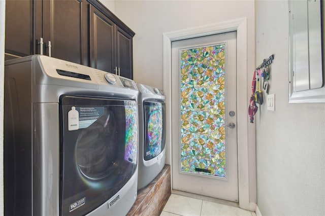 washroom with independent washer and dryer, cabinets, and light tile patterned floors