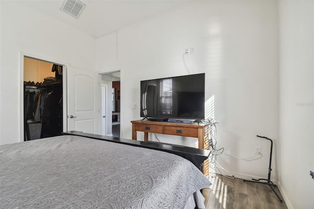 bedroom featuring a closet, a spacious closet, and wood-type flooring