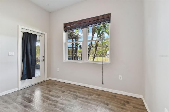 empty room with hardwood / wood-style flooring and a healthy amount of sunlight