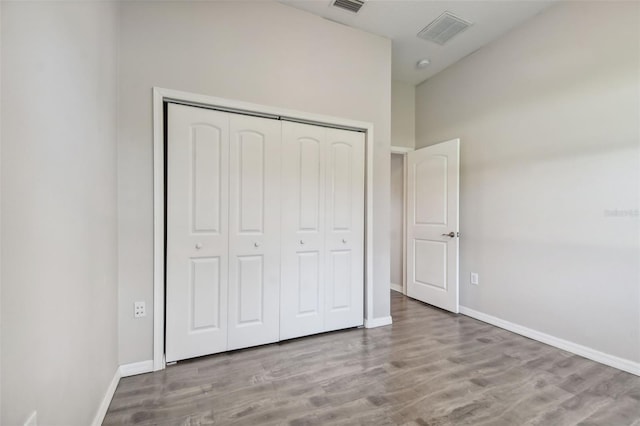 unfurnished bedroom featuring light hardwood / wood-style floors and a closet