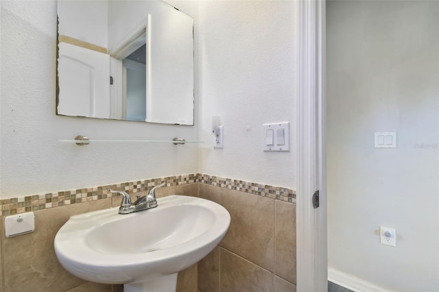 bathroom featuring tile walls and sink