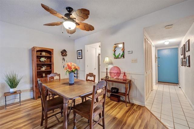 dining area with a textured ceiling, light hardwood / wood-style floors, and ceiling fan