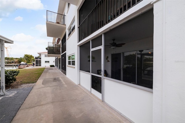 view of patio / terrace featuring a balcony, a water view, and ceiling fan