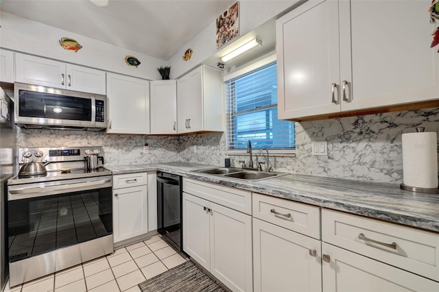 kitchen featuring a sink, backsplash, white cabinetry, stainless steel appliances, and light tile patterned floors