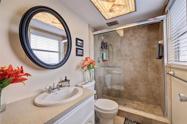 bathroom featuring vanity, toilet, visible vents, and a stall shower