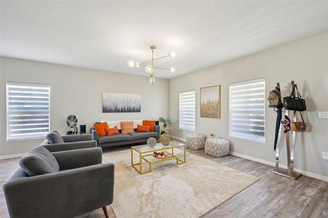 living room with a textured ceiling, hardwood / wood-style flooring, and an inviting chandelier