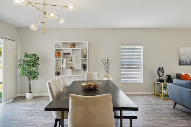 dining room featuring a notable chandelier, plenty of natural light, and light wood-type flooring