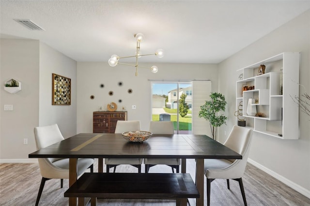 dining area with a notable chandelier and hardwood / wood-style floors