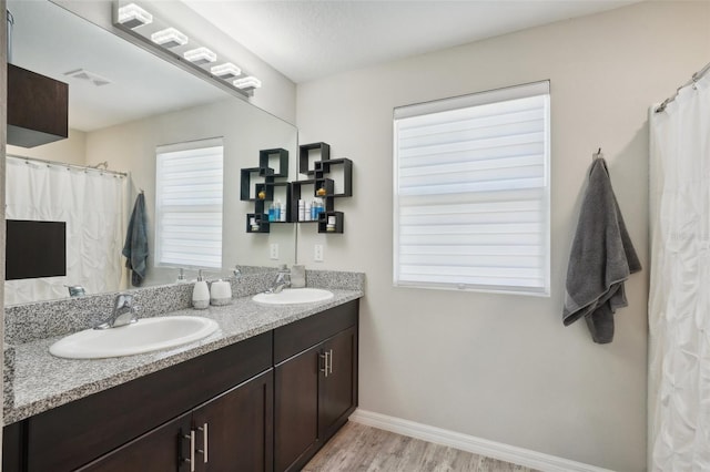 bathroom with vanity, hardwood / wood-style floors, and a healthy amount of sunlight