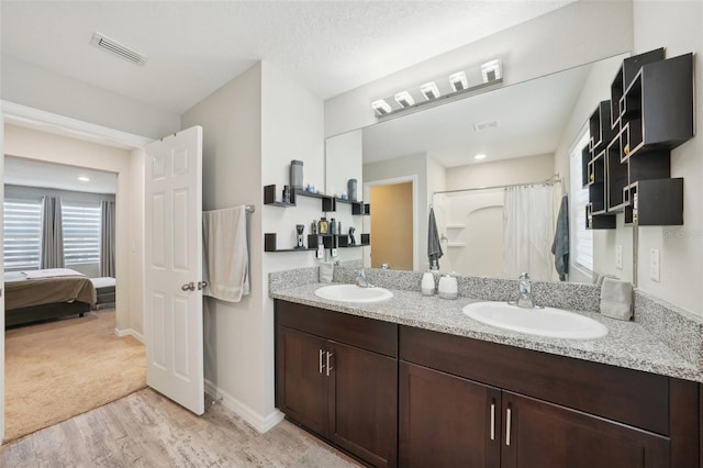 bathroom with vanity, hardwood / wood-style floors, curtained shower, and a textured ceiling